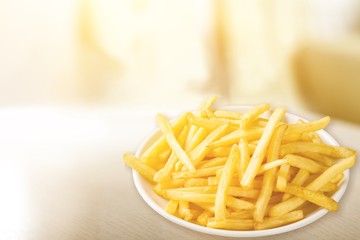 Plate of french fries on wooden table