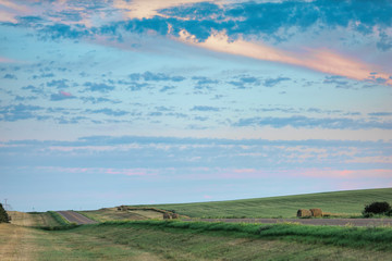 a long remote highway in rural North Dakota with a bright blue sky with clouds in the horizon