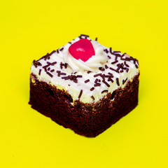 Chocolate cake on yellow background. Minimal creative food art