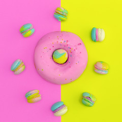 Donut and macaroons on colored background. Flat lay food vanilla candy design