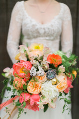 Colorful wedding bouquet with peonies, poppies, and greenery, orange, pink and yellow