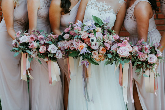 bride and bridesmaids holding wedding bouquets, pink bridesmaids dresses, detail shot, copy space