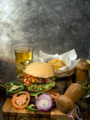 Homemade burgers with beer and cola made of bacon, pork, tomato, lettuce, onion, cheese and spices on wooden background
