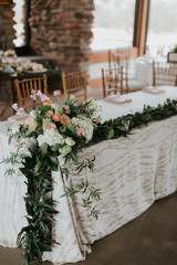 Flowers and Garland on Table at wedding reception, Greenery and florals wedding decor, modern and trendy 