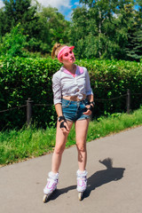 Portrait of an emotional girl in a pink cap visor and protective gloves for rollerblades and...