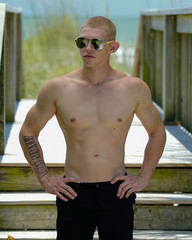 Obraz premium Young man walking by the beach with muscles