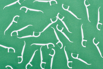 top view of white floss toothpicks isolated on green