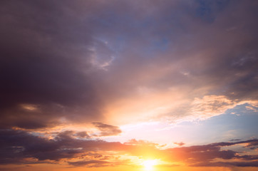 Naklejka na ściany i meble Bright sunset with rays on the background of thunderclouds.