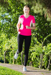 Girl in pink T-shirt is jogging