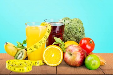 Glasses of fresh juice and fruits with vegetables and measuring tape