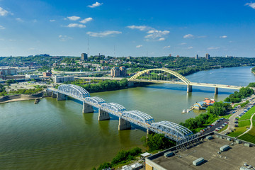 The yellow Daniel Carter Beard Bridge and the Purple People Bridge in Cincinnati Ohio over the Ohio river with blue sky