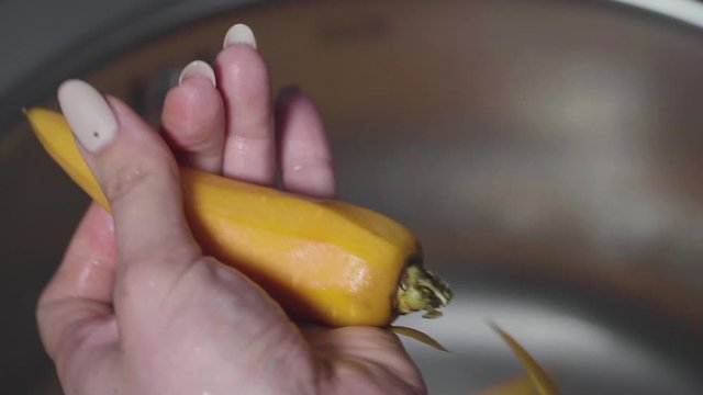 Women's hands wash, peel and cut vegetables into vegetable stew.
