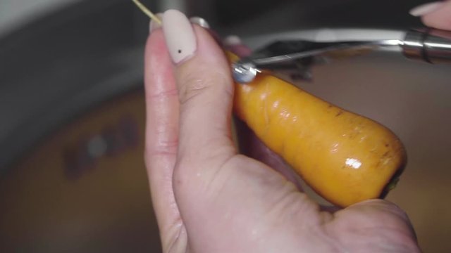 Women's hands wash, peel and cut vegetables into vegetable stew.