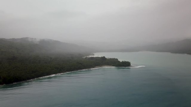 Foggy Papua New Guinea coastline and rainforest, aerial panning view