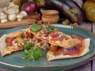 Pizza on thin dough.With slices of salami and ham ,olives and tomatoes. 