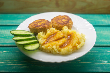Mashed potatoes with cutlets and cucumbers.