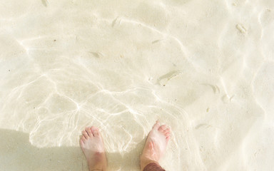Barefoot in the sea with fish swim.