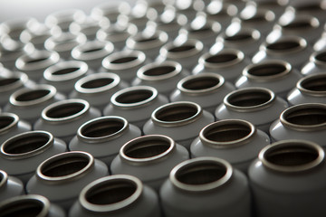 Numerous white aluminum aerosol cans against a white background. the boxes are in the raw form and in a row in a row.