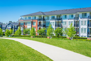 Concrete pathway across green lawn in front of residential condo building