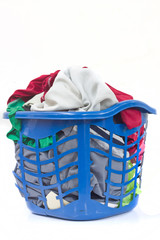 Overflowing clothes in laundry plastic basket blue on white background.