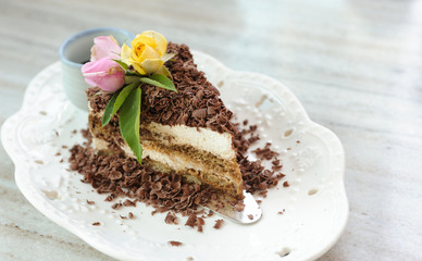 Green tea cake sprinkled with chocolate topping, placed on a plate and placed with roses on top,Selective focus