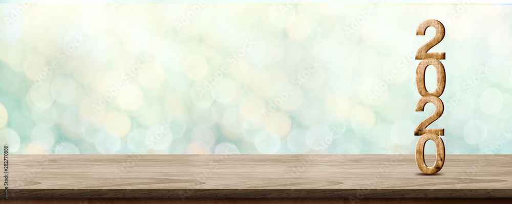 Poster happy new year 2020 wood with sparkling star on brown wood table with green bokeh background,holiday