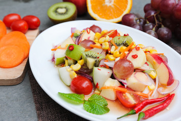 Mix spicy fruit salad on white dish lay on sackcloath,Mix spicy fruit,Thai food,Selective focus