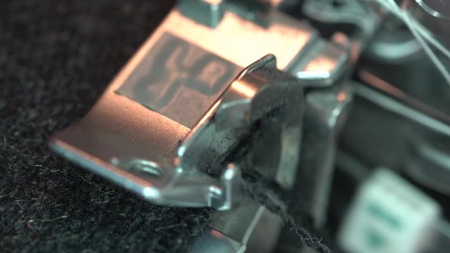 Serger.  An overlock sewing machine cuts the edges of the cloth as they are fed through. Presser foot close up