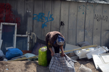 The elderly woman is looking for something useful in the trash . Ukrainian pension below the...