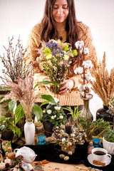 Still life with dry flowers and willow branches on a wooden table. Decor. decorations, dry branches of willow and a girl on the background. The concept of a traditional Russian holiday Palm Sunday.