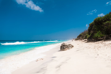 Tropical beach with white sand, blue ocean and waves