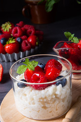 delicious milk rice with different berries and red fruit jelly