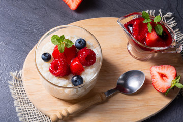 delicious milk rice with different berries and red fruit jelly