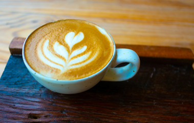 Morning coffee with Latte art heart shape, on the wooden table