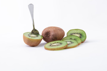 Delicious fresh kiwi snack - A whole kiwi, one cut in half with a spoon and slices of green kiwi...