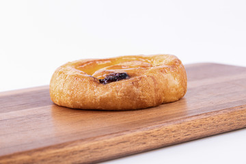 A roll of puff pastry with honey on top of a cutting board