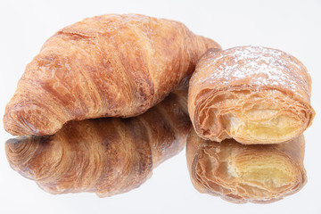 Close-up of a delicious puff pastry and freshly baked croissant on a mirror