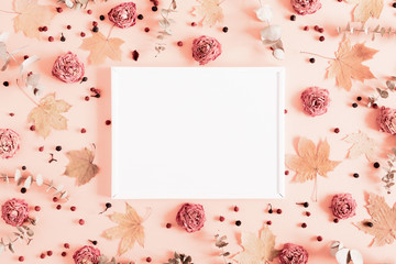 Autumn creative composition. Blank frame, eucalyptus, berries, leaves, roses, flowers on pastel pink background. Thanksgiving Day concept. Fall, autumn background. Flat lay, top view, copy space