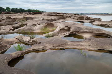 Fototapeta na wymiar River Island. Rocks from water erosion. 