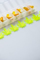 Pillen, Tabletten, Kapseln mit Cannabis Marihuana Hanf und CBD gegen Schmerzen zur Therapie als Medizin Arzneimittel in Pillenbox