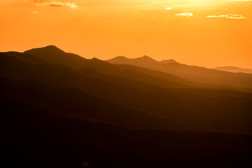 Stunning sunset in the mountains. Orange sky and mountains silhouettes. Carpathian Mountains. Bieszczady. Poland