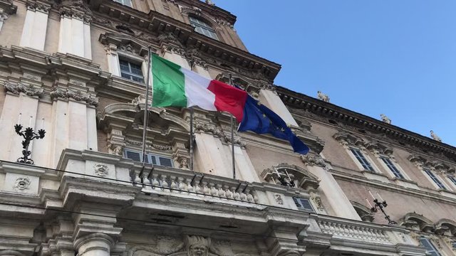 italian and european flags vawing together in the wind on the facade of government palace