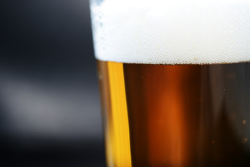 Glass of light beer close-up on a dark background