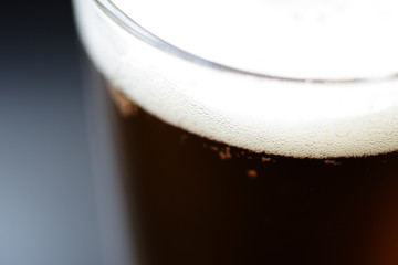 Glass of light beer close-up on a dark background