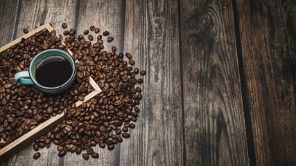 cup of coffee and beans on brown wooden table with text space
