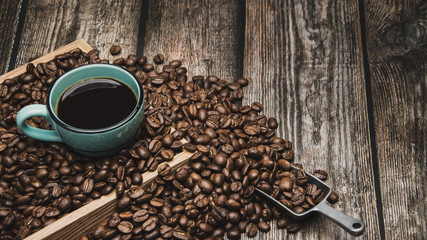cup of coffee and beans on brown wooden table with text space