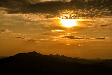 Stunning sunset in the mountains. Orange sky and mountains silhouettes. Carpathian Mountains. Bieszczady. Poland