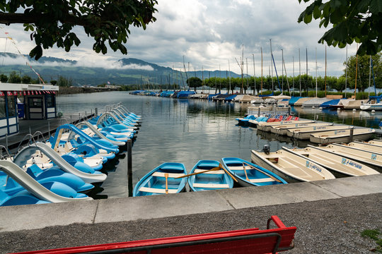 many rowboats and paddleboats on the harbor in Rapperswil waiting to be rented out
