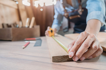 Carpenter working with equipment on wooden table in carpentry shop. woman works in a carpentry shop.