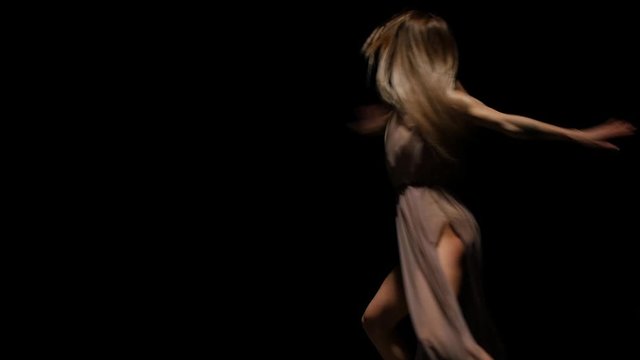 Talented lady performing contemp in dark studio at spotlight. Slow motion